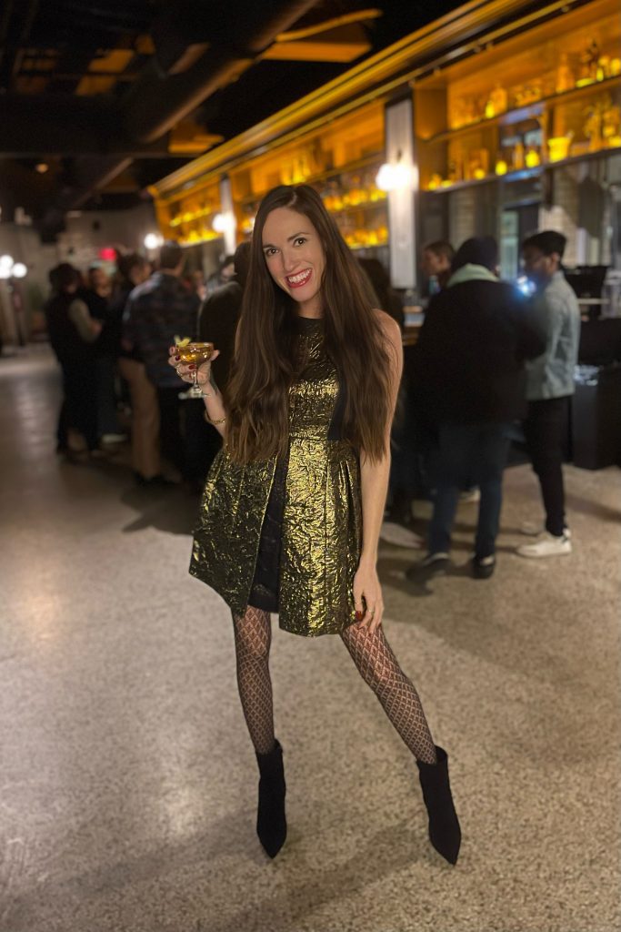 full length photo of woman in gold dress holding cocktail at sundry and vice indianapolis